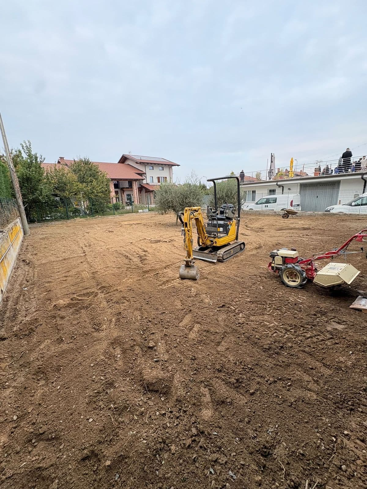 Terreno lavorato con mini escavatore e motocoltivatore, pronto per il nuovo prato